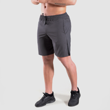 a fit men stand at right and wearing short dark grey with shoes black