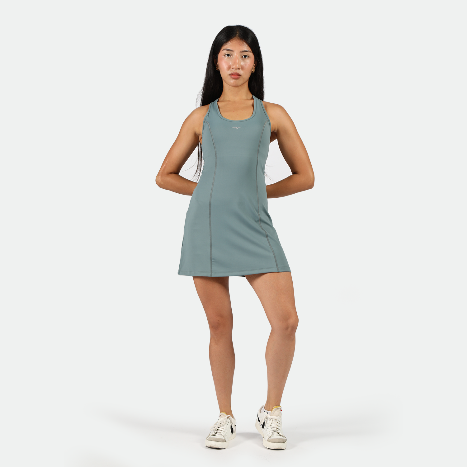 a fit woman wearing  dress green with sneakers 