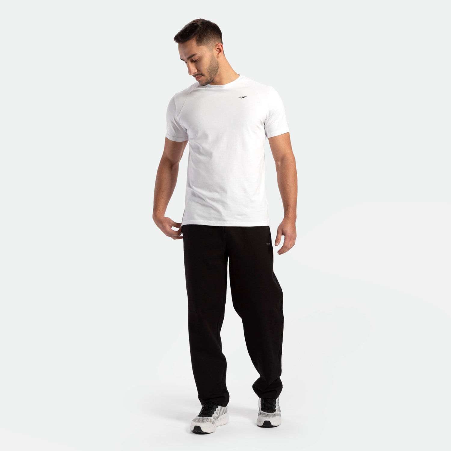a fit man wearing t-shirt white  with pants black and shoes