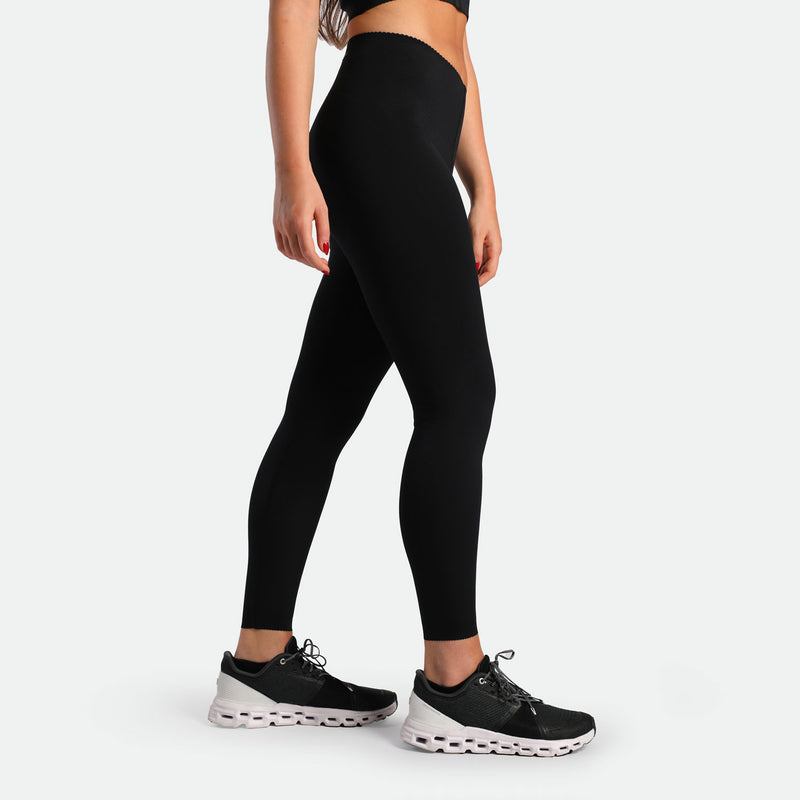 a fit woman stand at right and wearing legging  black with shoes black 