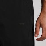 Close-up of a black jacket with a brand logo and a hand touching the fabric.