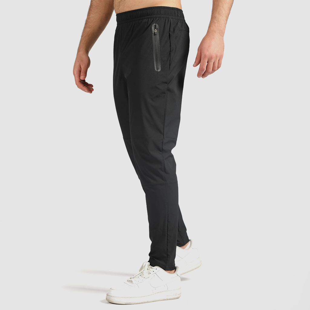 a fit man stand at right and wearing pants black ,plus the shoes white 