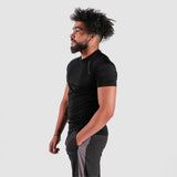 a fit man stand at right and wearing t-shirt black with pants grey   