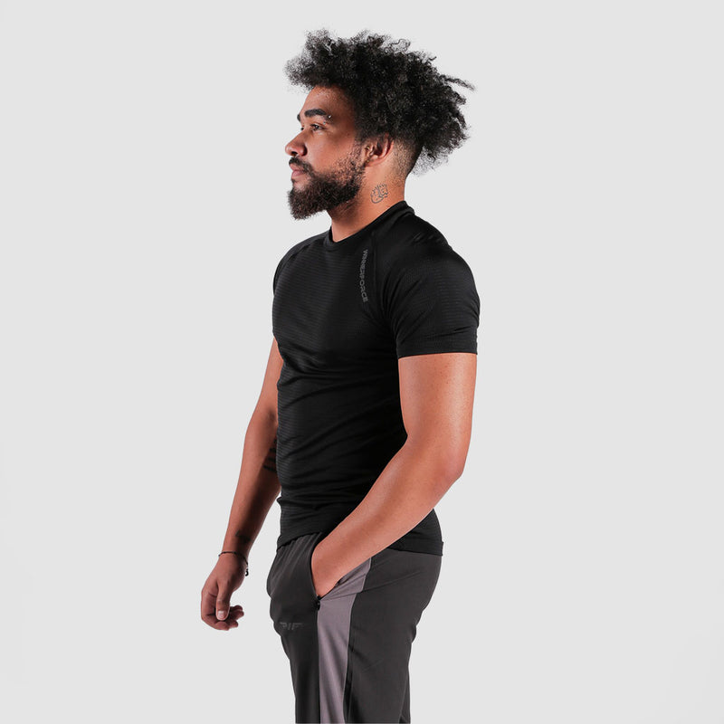 a fit man stand at right and wearing t-shirt black with pants grey   