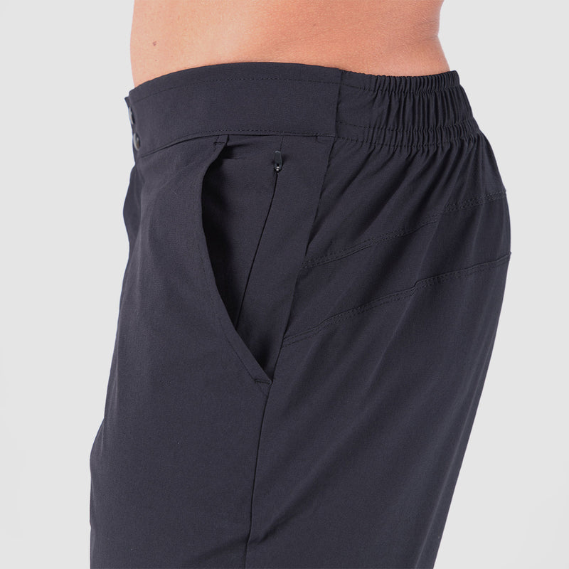 a fit man stand at right and wearing  pants black  with pocket black and zipper 