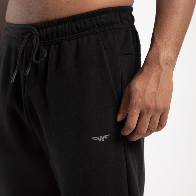close up view for fit man wearing jogger pants caviar black with logo 