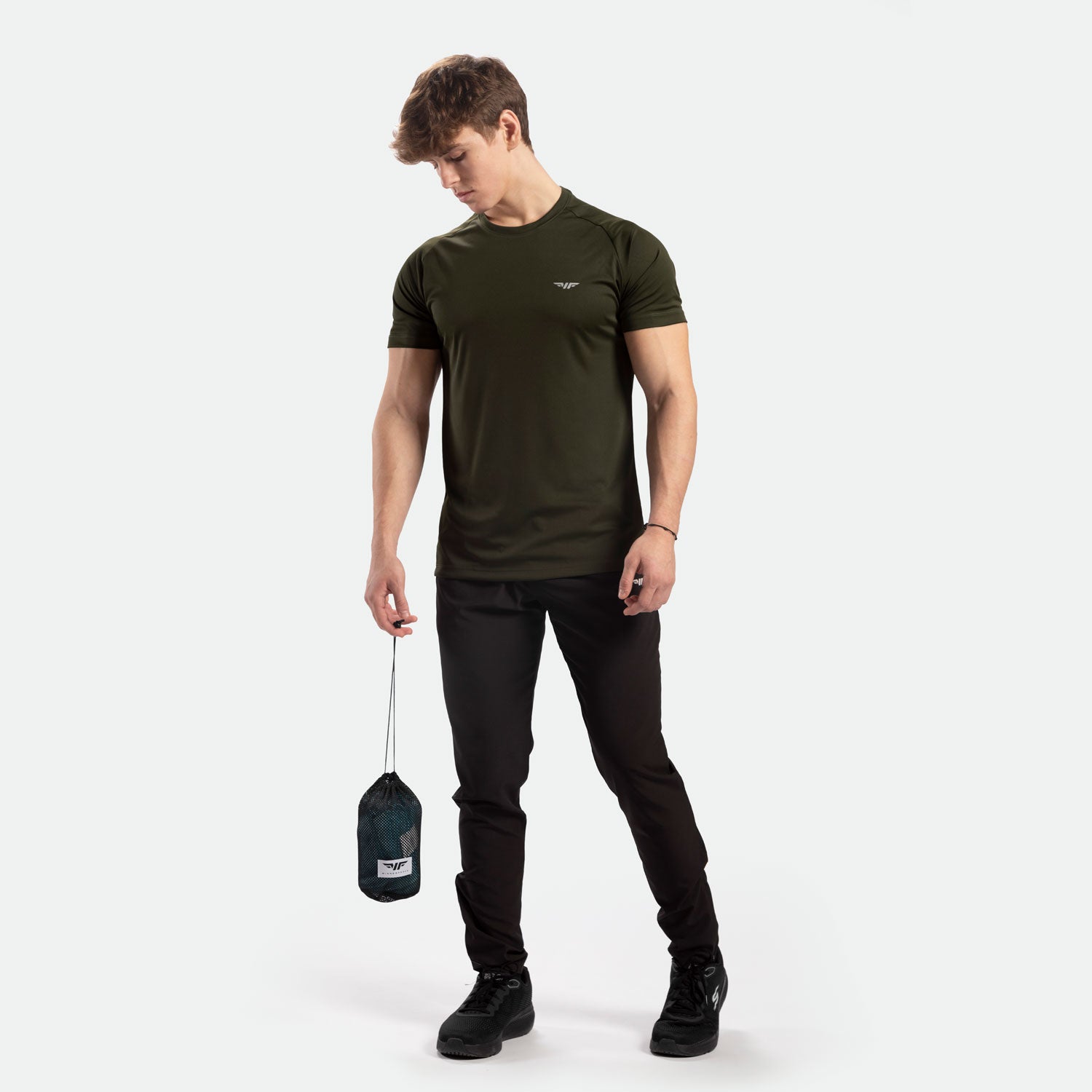 a fit man wearing t-shirt dark olive with logo and pants black ,plus shoes 