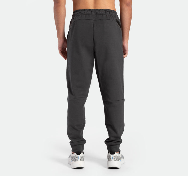 a back view for fit man wearing  pants grey ebony with shoes sports 