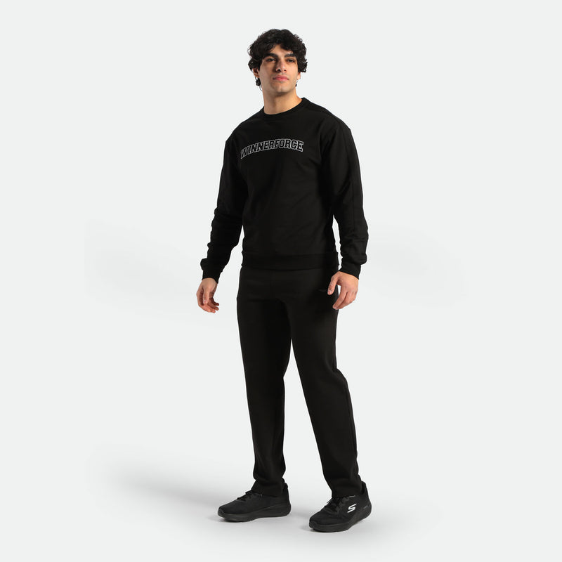 a fit man stand at right and wearing matching set black ,hoodie and pants ,plus the shoes 