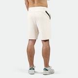 a back view for fit man wearing short beige ,plus the shoes 