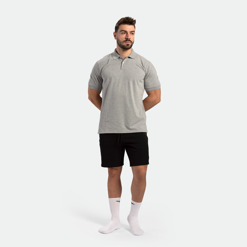 a fit man wearing t-shirt light grey with short black with socks white 
