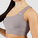 a woman wearing sports bra  grey ,plus  logo and background  light grey