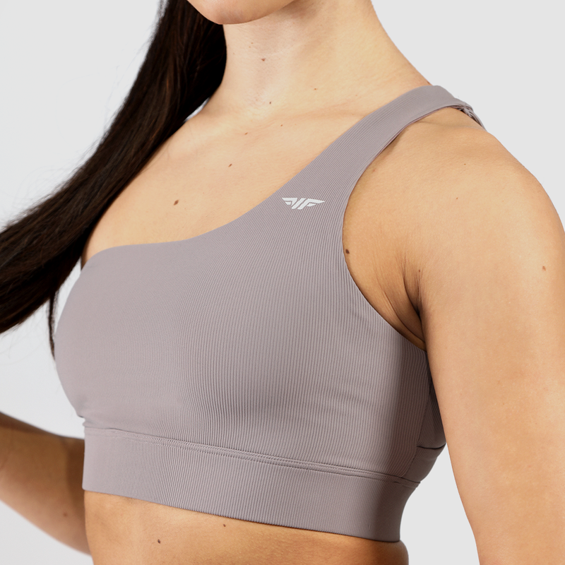 a woman wearing sports bra  grey ,plus  logo and background  light grey