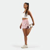 a fit woman stand at right with pose sport and look at the same direction ,she wearing  sport bra white  with nectar pink short 2 in 1 ,plus the background is light grey 