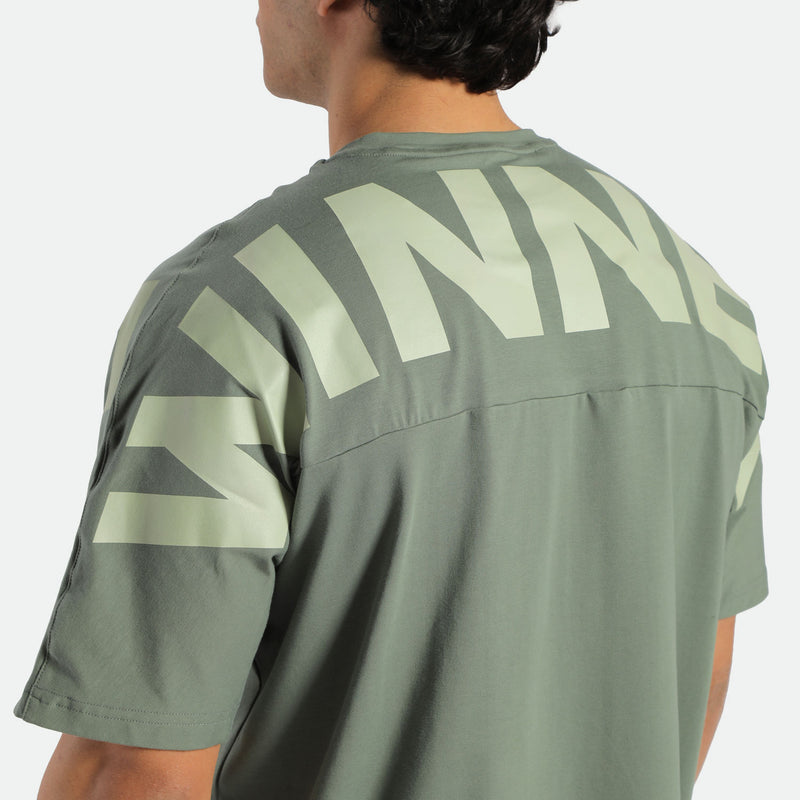 close up view for back view of fit man wearing t-shirt agave green with logo 