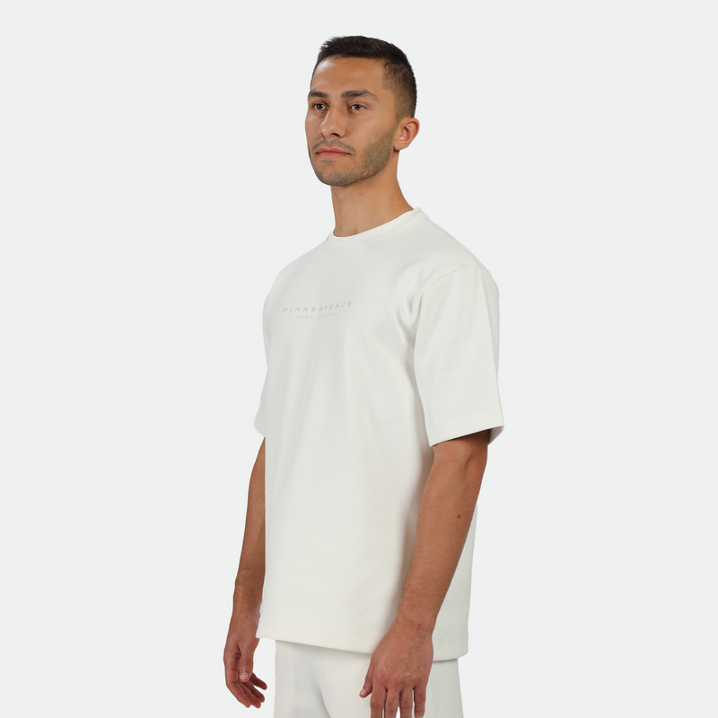 a fit man stand at right and wearing matching set off white ,t-shirt and short 