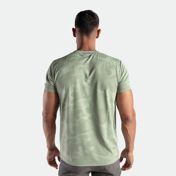 a back view for man wearing camo t-shirt green bay with pants grey 