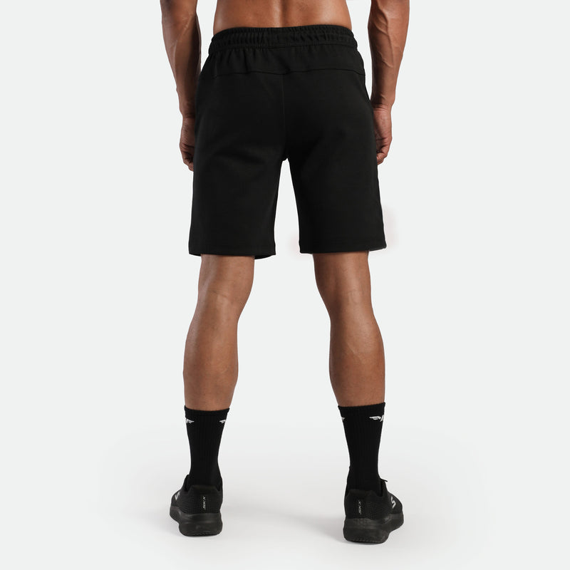 a back view for fit man wearing short black , plus the socks and shoes black 