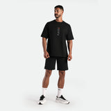 a fit man wearing matching set black ,t-shirt with logo , and short black ,plus the socks white with shoes 