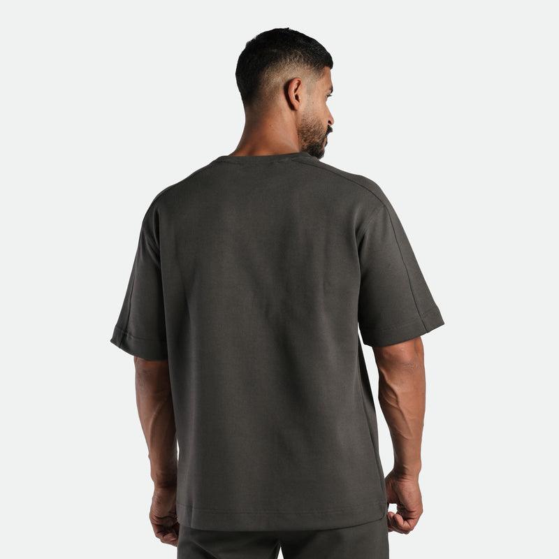 a back view for fit man wearing matching set iron dark grey ,t-shirt and short 