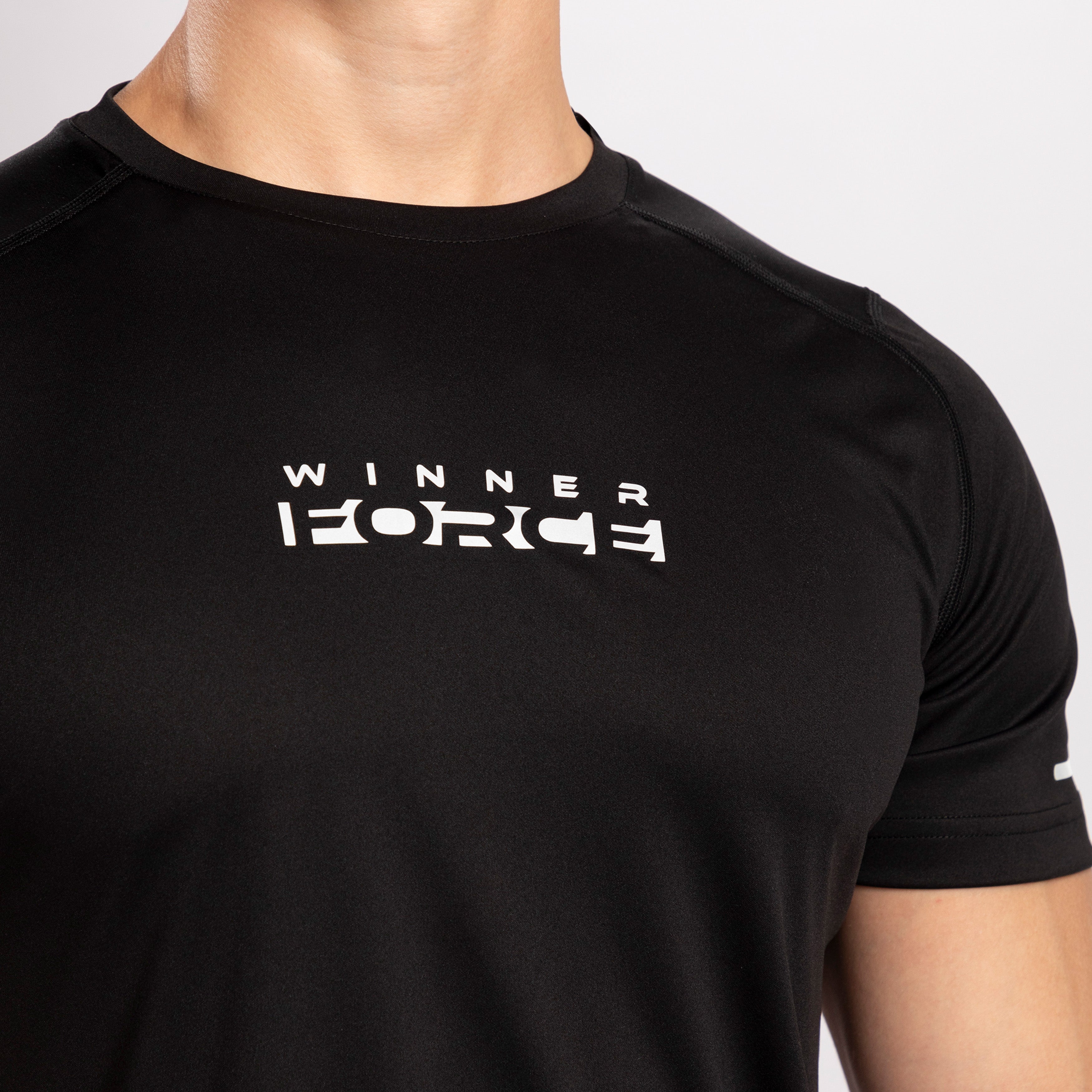 A close-up of the word WinnerForce on a t-shirt of color black.