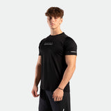 Side view of a man wearing a performance fit t-shirt in the color black. He is also wearing the tri short.