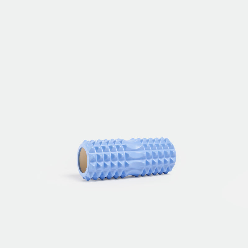 A light blue foam roller with a textured surface featuring a pattern of rectangular ridges. The roller is positioned horizontally on a plain, light background.