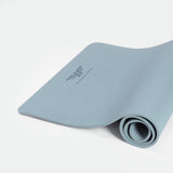 A rolled up chambray blue training mat with a visible logo on the surface.
