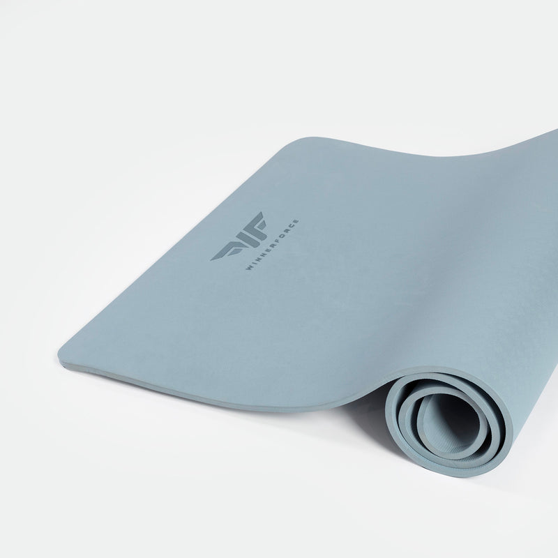 A rolled up chambray blue training mat with a visible logo on the surface.