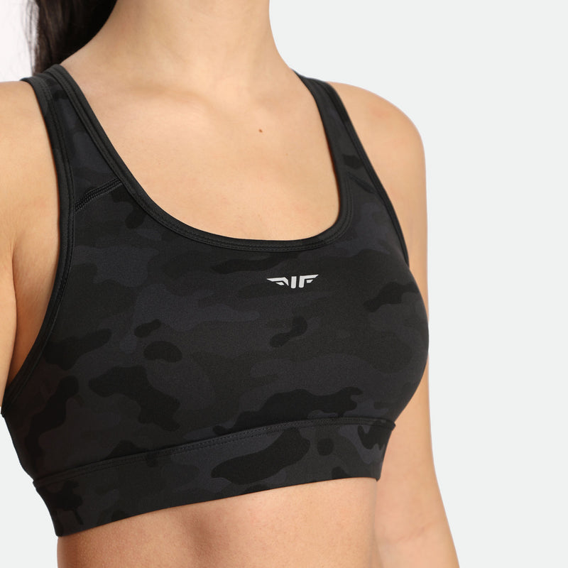 close up view for fit woman wearing camo sports bra with logo 