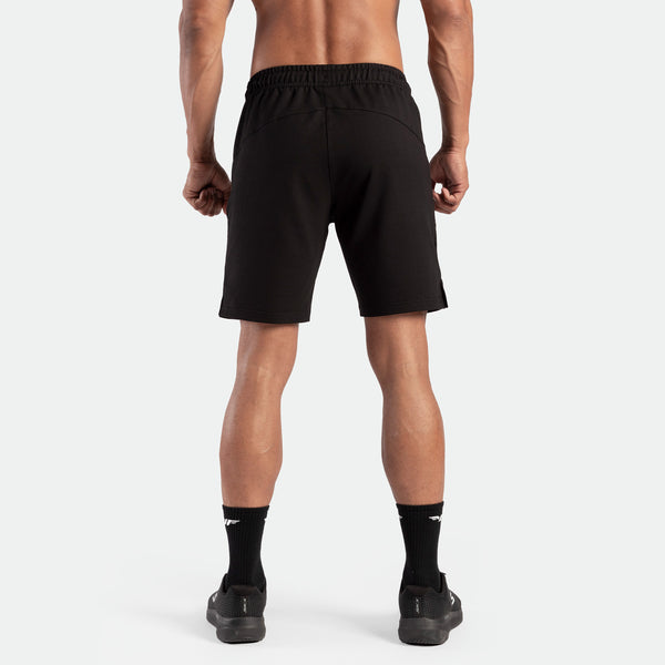 a back view for fit man wearing short  black ,plus the socks and shoes black 