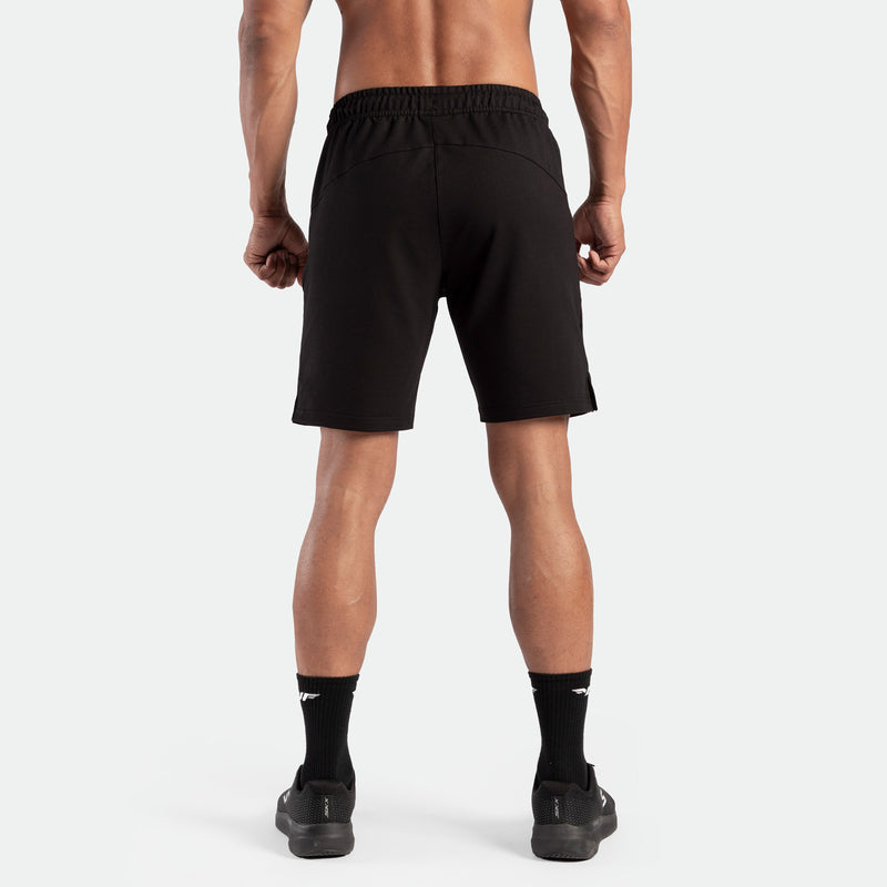 a back view for fit man wearing short  black ,plus the socks and shoes black 