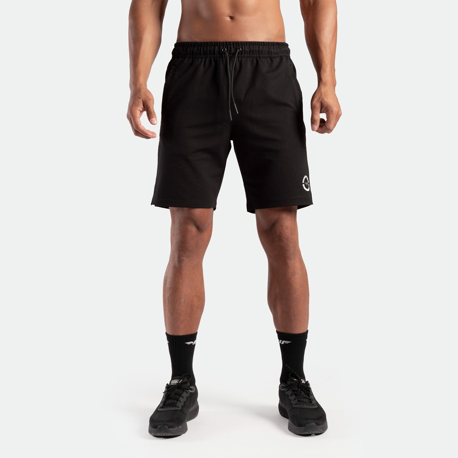 a fit man wearing short black with lace and logo ,plus the socks and shoes black 