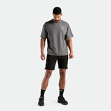a fit man wearing t-shirt grey with logo and short black ,plus the socks and shoes black 