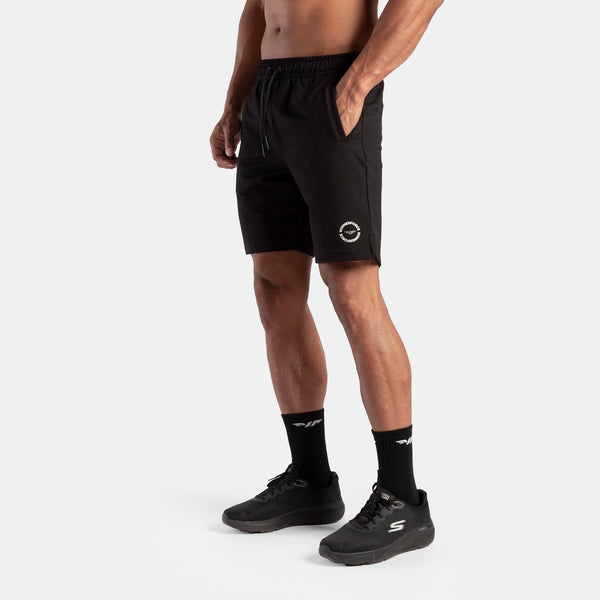 a fit man wearing short black with logo and lace , plus the socks and shoes black 