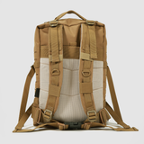 Tan and beige backpack shown from the back, featuring padded shoulder straps, adjustable waist and chest belts, mesh back panel, and multiple attachment loops, photographed against a plain light background