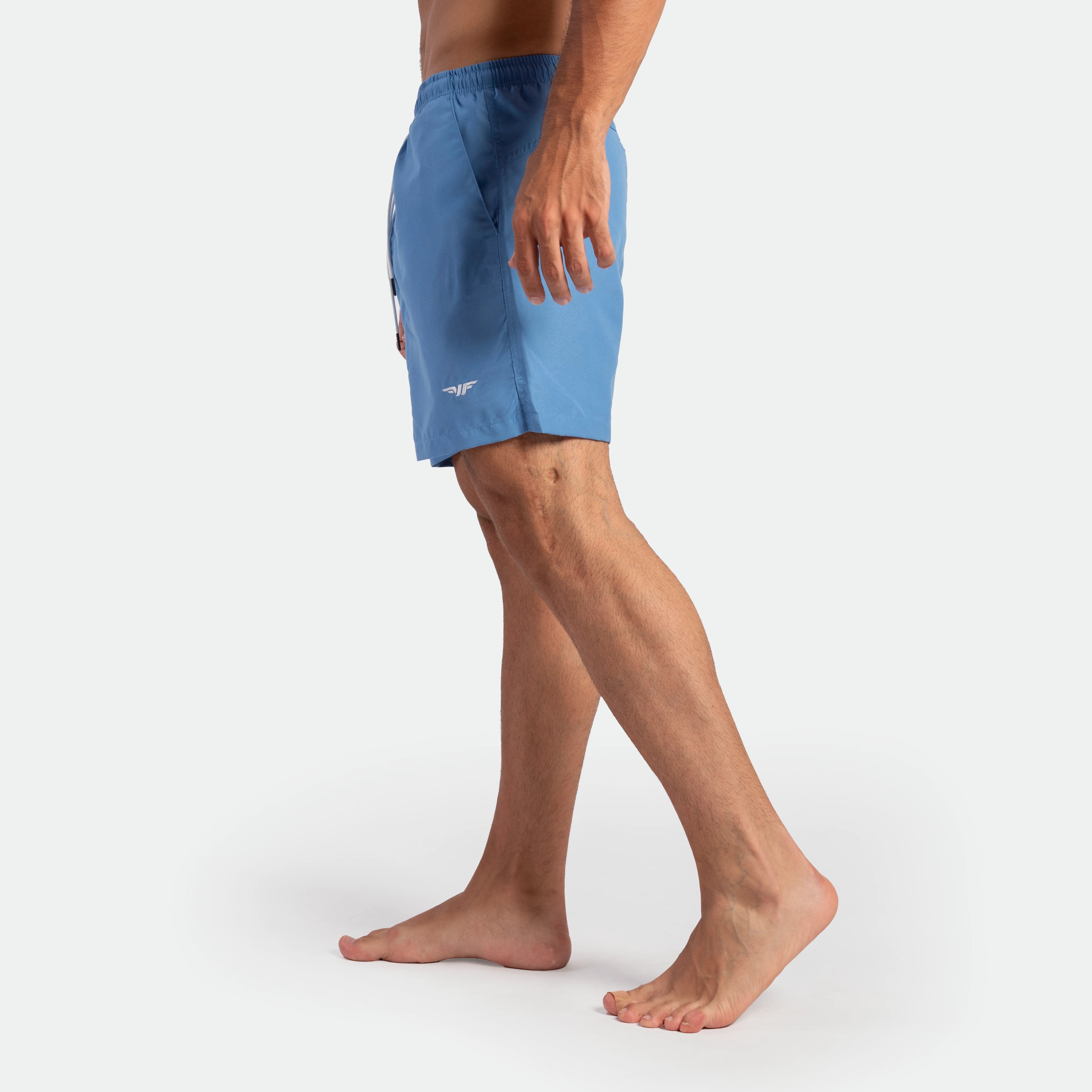 a fit man stand at right and wearing  short Marina blue 