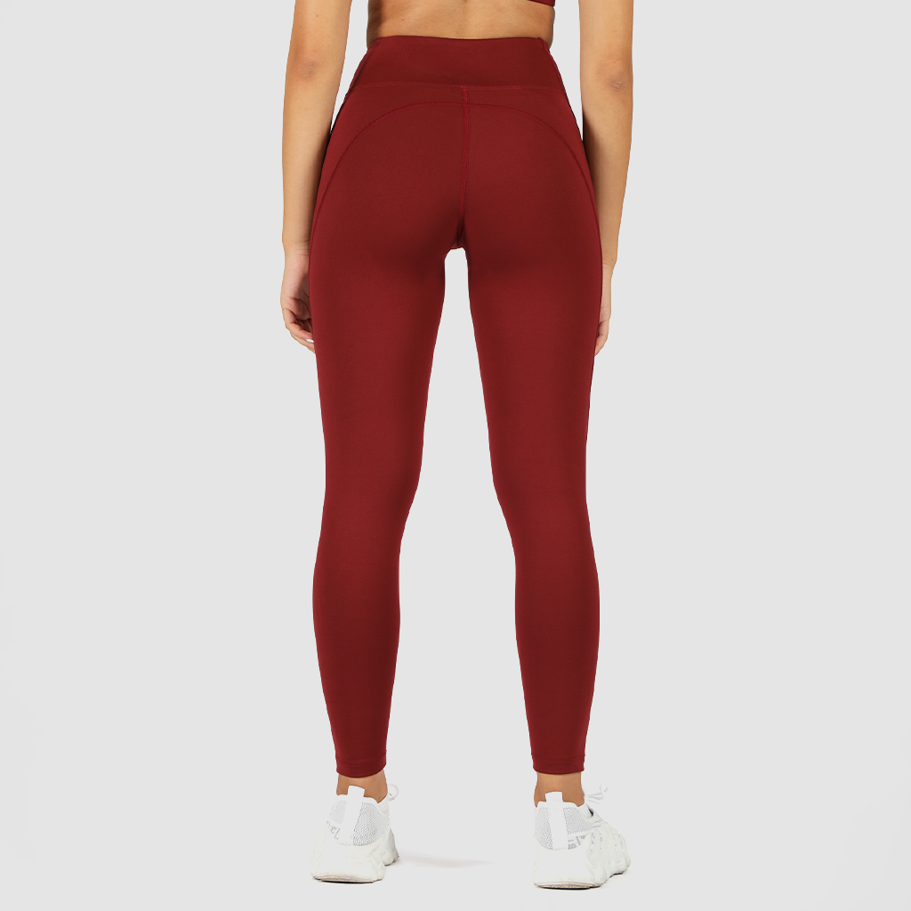 a back view for woman wearing legging red with shoes white, plus  the background is light grey 