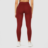 a back view for woman wearing legging red with shoes white, plus  the background is light grey 