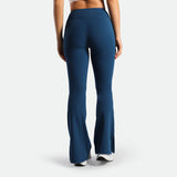 a back view for fit woman wearing flared legging Poseidon blue with shoes white 