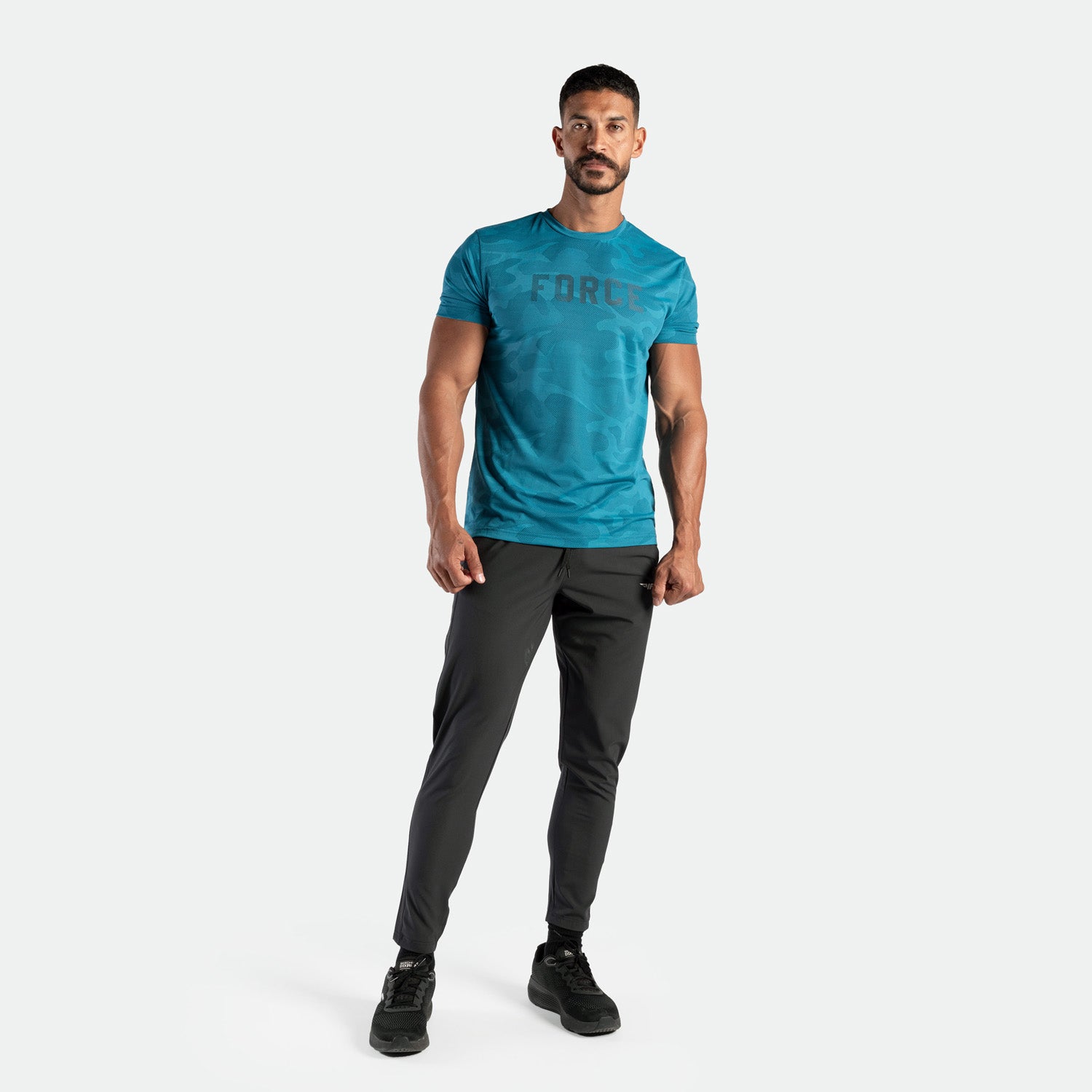 a fit man wearing t-shirt camo Saxony blue with logo and pants grey ,plus the shoes black 