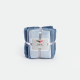 A neatly stacked towel set in shades of blue, tied with a silver ribbon and displaying a label. The image conveys softness and elegance.