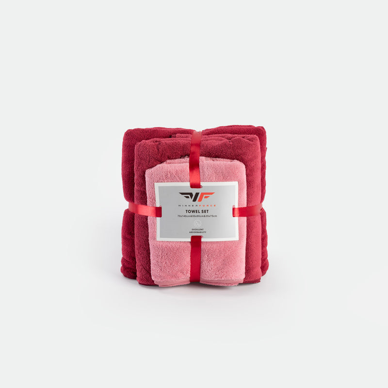 A neatly folded towel set includes burgundy and pink towels, tied with a red ribbon. The packaging label highlights "Towel Set" and gives a sense of luxury.