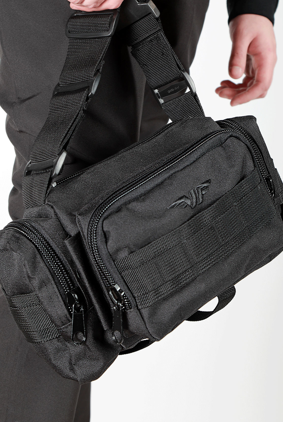 close up view for  black duffel bag with multiple zippered compartments and an adjustable shoulder strap, plus the logo 