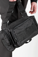 close up view for  black duffel bag with multiple zippered compartments and an adjustable shoulder strap, plus the logo 