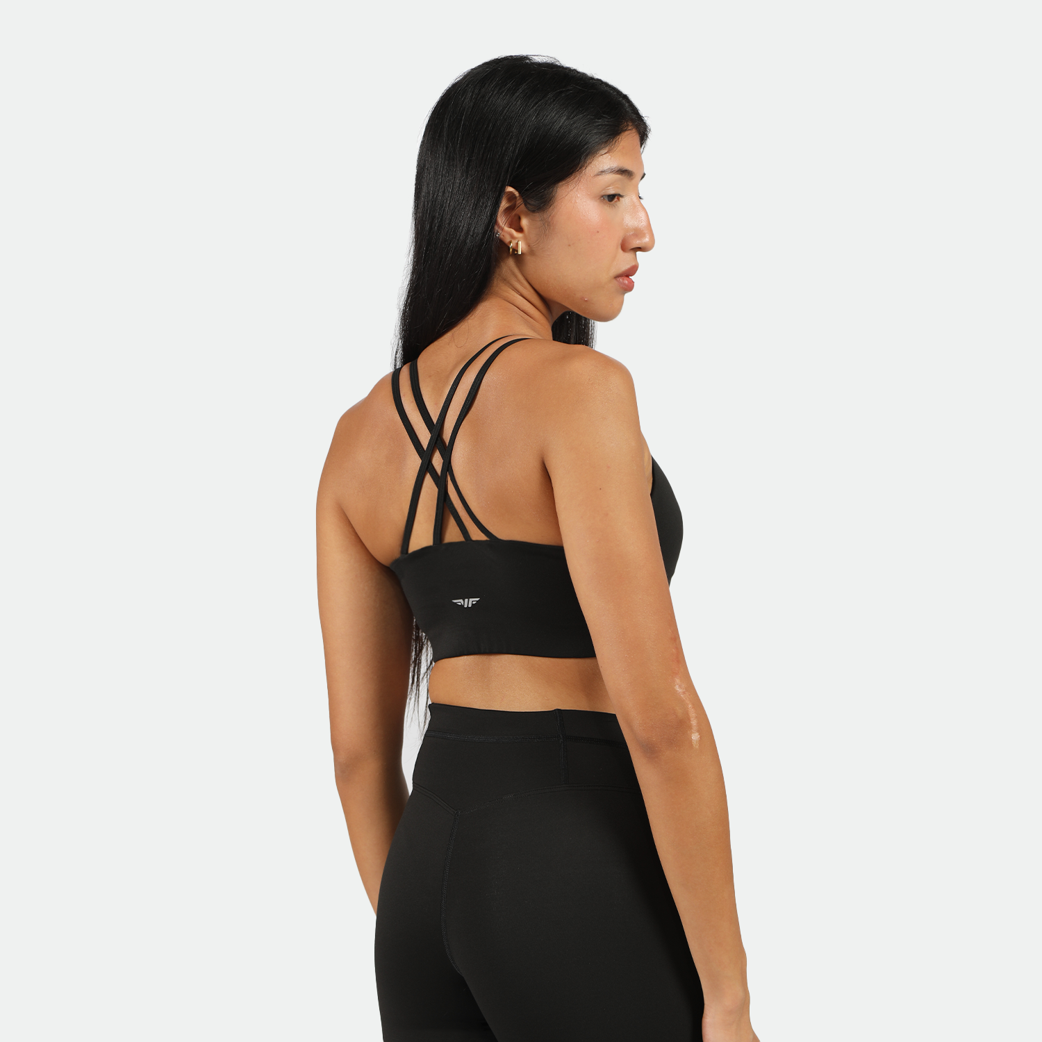  Back view of woman wearing black sports bra and leggings, bras feature special design and logo