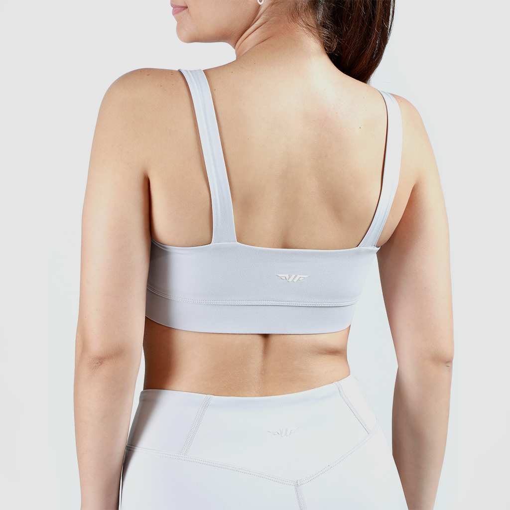 a back view for woman wearing matching  bra and  lagging with background  light grey 