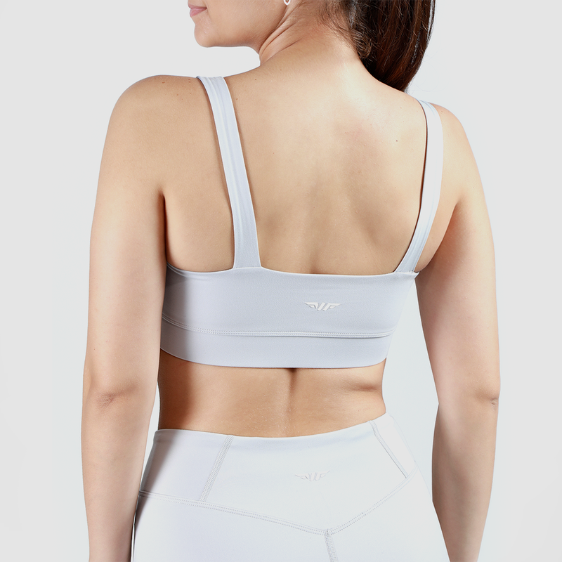 a back view for woman wearing matching  bra and  lagging with background  light grey 