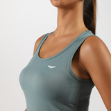 close up view for fit woman wearing tank green with logo 