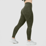 a fit woman stand at right and wearing olive  camouflage  legging  with shoes white ,plus the background is light grey 